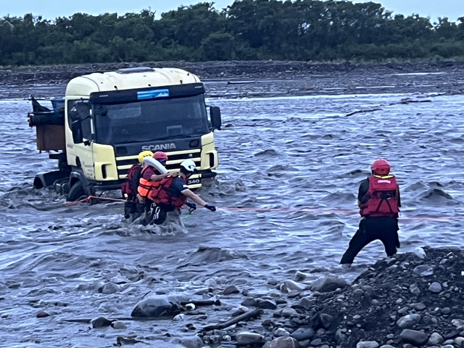 蘭陽溪水暴漲曳引車司機受困車內　消防人員搏命拉繩救人